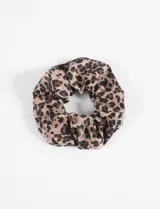 Gomita para el pelo tipo scrunchie confeccionada en poliéster con estampado animal print de leopardo en tonos beige, marrón y negro.