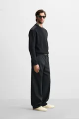 Sweater negro de punto con cuello redondo y manga larga. Presenta parches combinados a tono en hombros y codos.