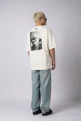 Remera negra oversize de algodón premium con cuello redondo y mangas cortas. Presenta un logo bordado en el frente y un parche estampado en la espalda.