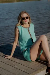 Conjunto tejido de algodón color verde agua con detalles en marrón. Incluye un chaleco con botones y un short de tiro alto.