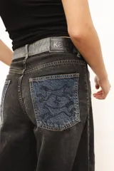 Pantalón de jean gris de corte recto y tiro medio, con bordado de estrella de ocho puntas en los bolsillos traseros.