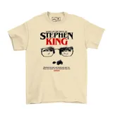 Remera blanca con estampado de la cara de Stephen King y la frase "Based on the novel by Stephen King".