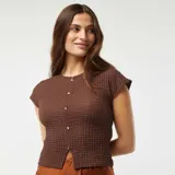 Camiseta marrón de punto gofrado con cuello redondo, mangas cortas y cierre frontal con botones dorados.