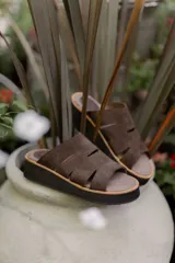 Sandalias marrones de gamuza con plataforma y tiras con aberturas.