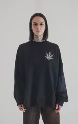 Buzo negro de corte holgado con bolsillo con cierre en la manga y estampado de hoja de cannabis en el pecho.