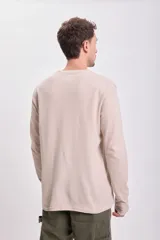 Remera manga larga color beige claro con textura acanalada.