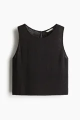 Musculosa negra en tejido de punto texturizado con escote redondo y abertura de cerradura con botón en la nuca. Sin mangas.