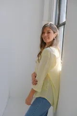 Blusa color amarillo pálido con cuello en V, manga 3/4 y calados con forma de paisley.