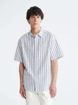 Camisa de manga corta con diseño de doble raya, confeccionada en algodón suave y transpirable, con cuello de punta y cierre de botones.