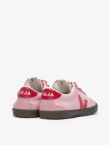 Zapatillas Veja modelo Volley, color rosa con detalles en rojo. Fabricadas con cuero bovino y suela de caucho amazónico.