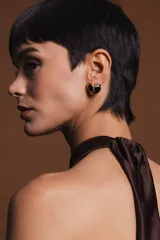 Aros dorados con detalle de esmalte negro en forma de corazón.