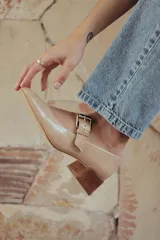 Zapatos de charol color beige con taco bloque de madera y tira sobre el empeine con hebilla dorada.