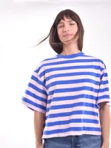 Remera blanca con rayas horizontales rojas, de corte holgado y mangas cortas.