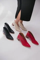 Botines color peltre de cuero con taco de madera y corte en V en el frente.