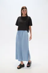 Pantalón capri de denim azul con cintura elástica y aberturas laterales en el ruedo.