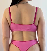 Conjunto de ropa interior color rosa chicle con detalles en fucsia, compuesto por un corpiño de algodón con elásticos y una bombacha de algodón con elásticos.