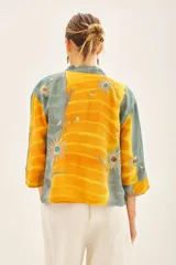 Kimono corto de viscosa con estampado tie-dye en tonos amarillo y verde azulado, con bordados en hilo de lurex. Incluye un cinturón de tela a juego.