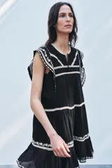 Minivestido negro de algodón con bordados florales blancos en cuello, mangas y ruedo.