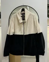Campera de polar combinada en blanco y negro, con cuello alto y cierre frontal.