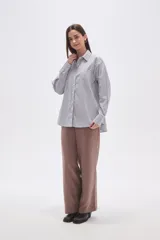 Camisa de algodón holgada con cuello camisa, botones frontales y estampado de rayas verticales finas en blanco, negro y rosado.