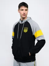 Campera deportiva negra con capucha y detalles en amarillo, cierre frontal y escudo del Club Atlético Peñarol en el pecho. Presenta cortes y cambios de color en mangas y cuerpo, y un estampado en la espalda.