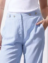 Pantalón celeste a rayas verticales, de lino, corte wide leg y tiro alto con botones decorativos.