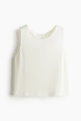 Musculosa color crema de punto texturizado con escote redondo y abertura de cerradura con botón en la nuca. Sin mangas.