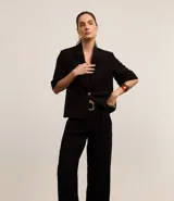 Pantalón de vestir de corte palazzo color negro, con cintura alta, trabillas, cierre tradicional y pliegues.