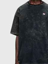 Remera Diesel de corte holgado, color negro con efecto gastado y logo pequeño en el pecho.
