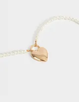 Collar corto de perlas blancas con dije dorado en forma de corazón con forma de candado.