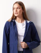 Campera impermeable azul con cierre central, bolsillos delanteros y lazo de ajuste en la cintura. Tiene avíos metálicos plateados y cierre oculto en la espalda para autoguardado.