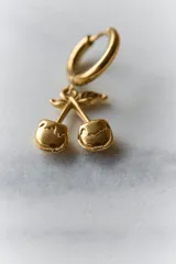 Par de aros plateados con forma de cerezas colgando de un aro pequeño.