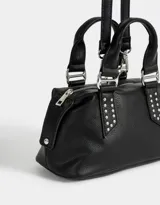 Cartera bowling negra de cuerina con tachas decorativas, doble asa de mano corta y correa regulable y desmontable.