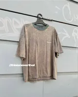 Remera marrón con cuello redondo y logo pequeño estampado en el pecho.