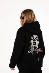 Buzo hoodie negro con capucha y cordones ajustables. Estampado en la espalda con la imagen de un rostro y la frase "Beyond Limits" en blanco y rojo.