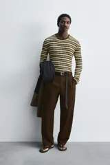 Jersey slim fit tejido en hilatura de algodón, con cuello redondo y manga larga. Diseño a rayas horizontales en tonos beige y marrón.