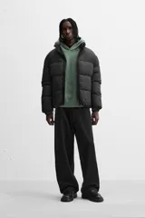 Campera puffer marrón con cuello alto, cierre frontal con cremallera, bolsillos laterales y puños elásticos.