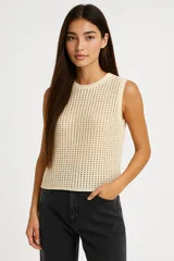 Musculosa color crema de tejido calado, sin mangas, con cuello redondo.