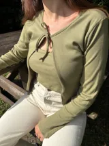 Saco de tejido ligero color beige, de manga larga y corte abierto, con cuello redondo.