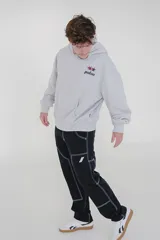 Canguro gris con capucha y bolsillo delantero tipo canguro. Estampado en el pecho con el logo de la marca Pulau en negro y rojo.
