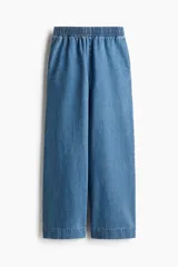 Pantalón culotte de denim azul claro, con cintura elástica fruncida, bolsillos laterales y corte holgado.