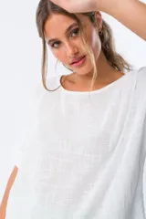 Blusa blanca de viscosa con escote redondo y mangas cortas.