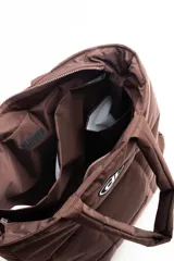 Bolso negro tipo tote bag, acolchado con diseño de cuadrados. Tiene doble asa de hombro y logo estampado en blanco.