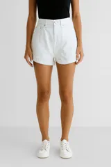 Short de jean blanco, tiro alto, corte ajustado y ruedo desflecado.