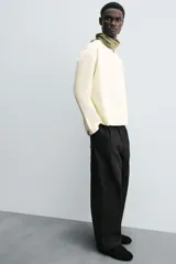 Camisa color crema de corte amplio, confeccionada en popelín de algodón. Tiene cuello redondo y mangas largas.