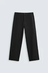 Pantalón negro de corte recto, con cintura elástica y cierre frontal de cremallera y botón. Presenta bolsillos delanteros y bolsillos traseros de vivo.