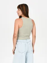 Musculosa negra ajustada al cuerpo, con cuello redondo y diseño de tirantes anchos tipo halter.