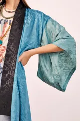 Kimono largo color celeste con estampado de textura y ribete negro.