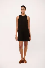 Vestido corto negro de lino italiano, con cuello redondo a la base y musculosa. Tiene detalle de desflecado en el cuello y a lo largo del vestido.