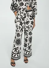 Pantalón wide leg de viscosa con estampado floral en blanco y negro. Tiene cintura elástica, dos bolsillos laterales y diseño largo.